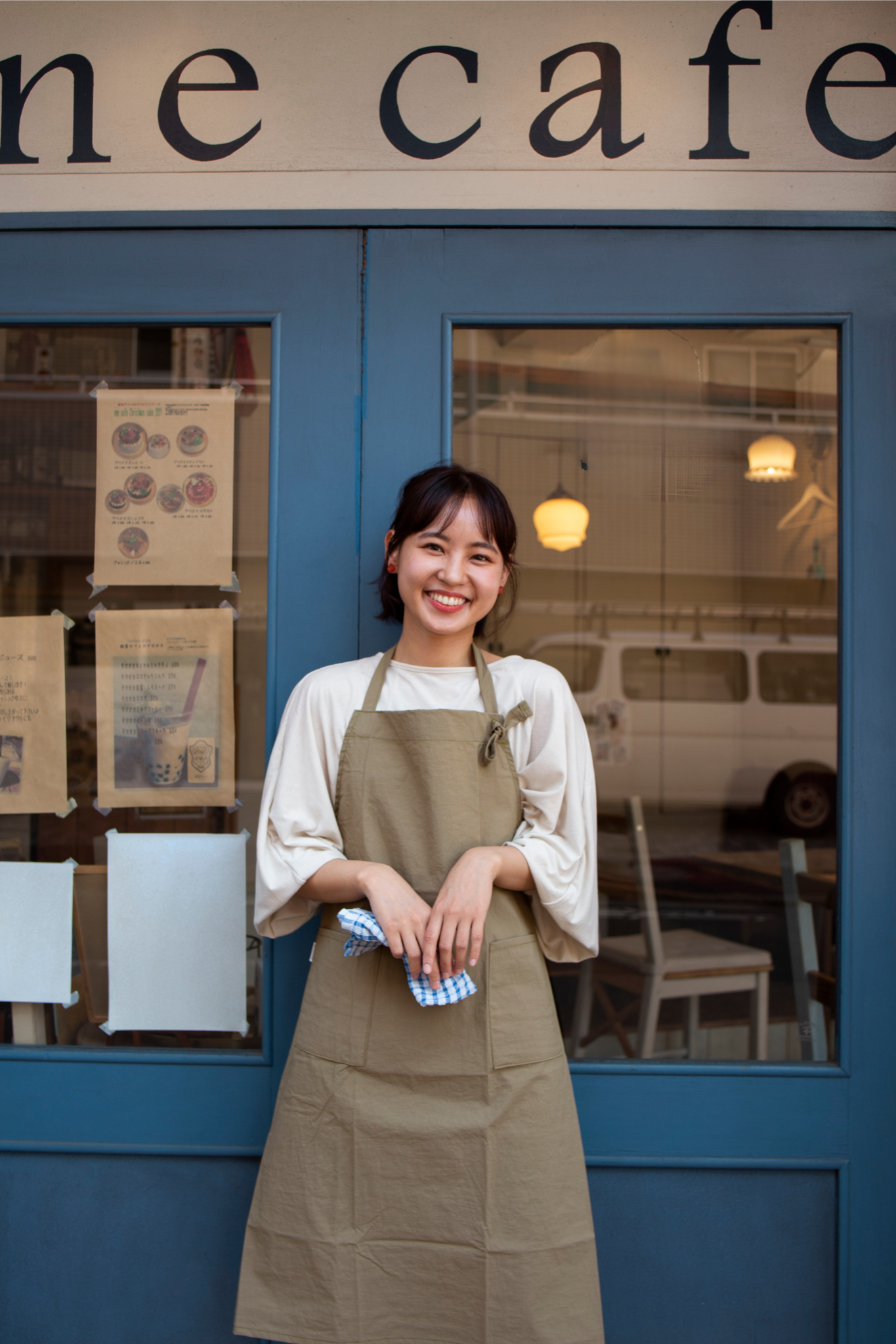 Cafe owner standing in front of store